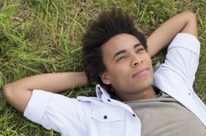 Contemplating Young African Man Lying On Grass