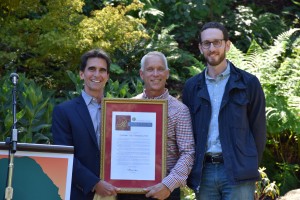 Senator Mark Leno (L) presents a proclamation from the  State of California to National AIDS Memorial executive director John Cunningham.  Also  pictured (R) with San Francisco Supervisor Scott Wiener.