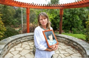 Katharine Prescott holds a portrait of her son, Kyler Prescott, in the garden she built in his memory outside our San Diego-area home. 