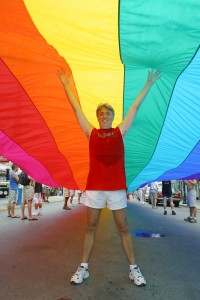 In this June 15, 2003, file photo, Gilbert Baker stands under a 1.25-mile-long rainbow flag on Duval Street in Key West, Fla.  Baker, the creator of the rainbow flag that has become a widely recognized symbol of gay rights, was found deceased March 31, 2017, in New York City. In 2003, Baker supervised production of the "sea-to-sea" rainbow flag to mark the 25th anniversary of its creation. Some 3,000 people helped to stretch the banner along Duval Street from the Atlantic Ocean to the Gulf of Mexico. (Rob O'Neal/Florida Keys News Bureau/HO)